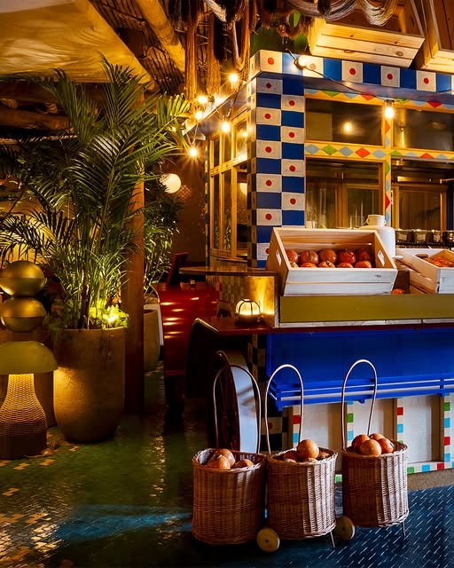 Cozinha italiana do Vila Medí com azulejos em azul e branco, caixas de tomates e cestos de palha